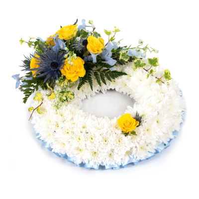 Wreath SYM-319 - This white massed wreath is finished with a blue and yellow spray for an extra special tribute.